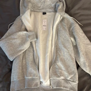 Grå oversized hoodie från Gina Tricot - Säljer en grå oversized zip hoodie i storlek S från Gina Tricot. Väldigt fin, aldrig använd och prislappen sitter kvar. Nypris 399kr🩶
