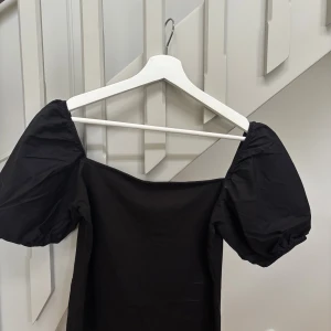 Svart  puffärmad blus  - Säljer en svart blus med puffiga kortärmar i storlek S och i fint skick. Säljes för 110kr. Skickas snabbt efter köp.  