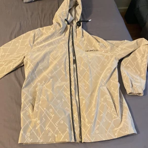 Beige Moncler vindjacka med mönster - Moncler jacka heltt ny använd den bara 1 gång och den va för stor på mig. Pris kan diskuteras.
