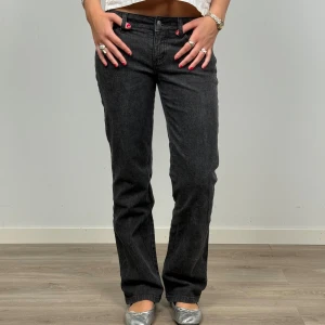 Svarta jeans  - Snygga svarta jeans med raka ben och coola diamanter samt dragkedjor på bakfickorna.  Materialet är jeans och passformen är straight, perfekt för dig som gillar en stilren look med edge.