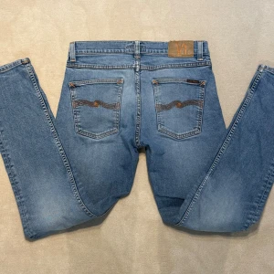Nudie Jeans - Ljusblå jeans från Nudie!                                    Modell: Lean Dean Storlek: W30 L32. Bra skick förutom en liten defekt se sista bilden som knappt syns. Nypris 1800kr. Skriv vid frågor.