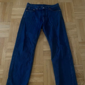 WEEKDAY mörkblå jeans straight fit - Klassiska WEEKDAY jeans i mörkblå denim med raka ben och femficksmodell. Jeansen har normal midja och knäppning fram. Perfekta för dig som gillar en tidlös och avslappnad stil.