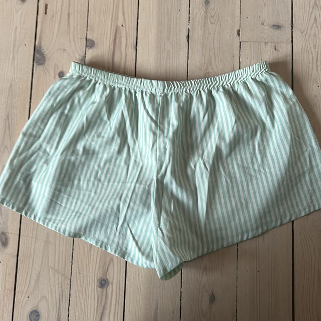 Grön- och vitrandiga shorts med snörning - 1