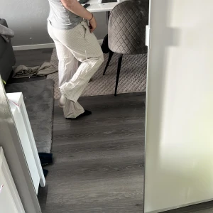 Randiga vida linnebyxor med snörning - Säljer ett par ljusa, randiga linnebyxor med avslappnad passform och snörning i midjan. Byxorna är beige 💗