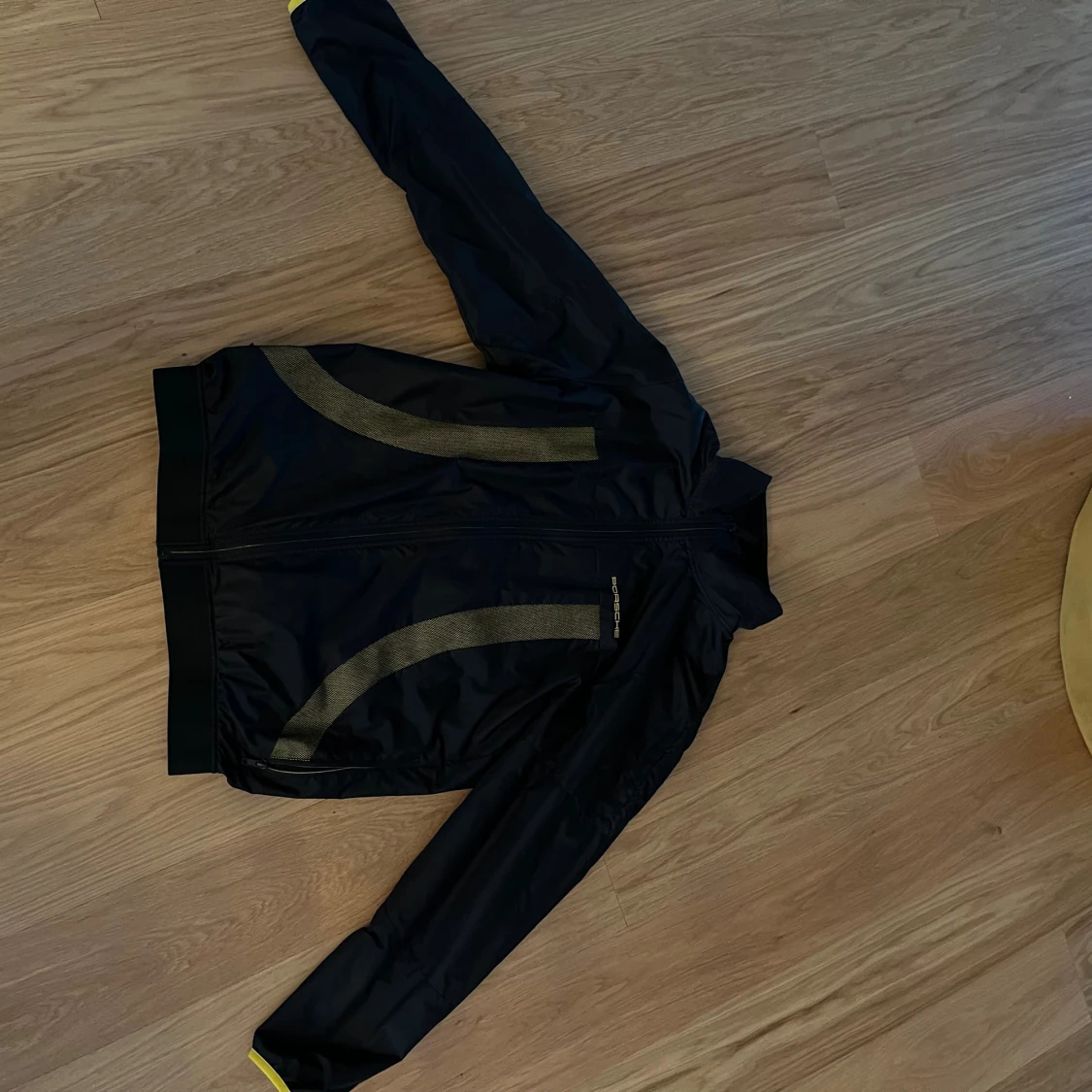 Svart Porsche vindjacka med gula detaljer