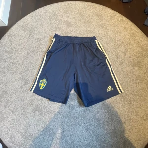 Adidas Shorts Sverige - Tja! Säljer dessa Mörkblå landslagsshorts från Adidas, dessa är spelare i landslaget som använder och går ej att köpa så dom är väldigt limiterade i mängden! Storlek M Passar även S