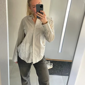 Beige skjorta med broderade blommor NA-KD - Cool skjorta från nakd. Helt ny med lapparna kvar. Nypris 599kr. 