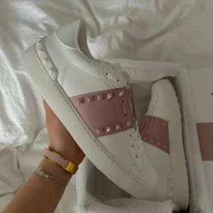 Valentino Rockstud sneakers vit/rosa - Säljer mina älskade Valentino Open-sneakers 💘 De har hängt med ett tag men är fortfarande i grymt fint skick. Perfekta om du vill se lite boujee ut utan att försöka för mycket 😎 Självklart äkta (men tyvärr ingen kvitto).