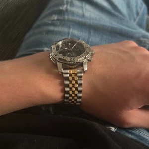 Tissot kronograf herrklocka stål/guld - Snygg Tissot kronograf med svart urtavla och tre subdials. Boett i rostfritt stål och vridbar bezel. Länkarmband i tvåfärgat stål och guldton. Klassisk och sportig design med tydliga index och datumfönster. Perfekt accessoar för dig som gillar stilrena detaljer. Köpte för 12 000, om den inte passar kan man ta bort länkar på klockarmbandet☺️