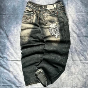 Vintage Embroidered Jeans – Y2K 2000s Streetwear - 🔥 Stylish vintage jeans with large embroidered back pocket design – bold and unique detail that makes these stand out. Washed denim with fading, wide/loose leg fit. Perfect for Y2K and streetwear styling.  📏 Measurements (laid flat):  Waist: 44 cm (~W33/W34) Hips: 48 cm Rise: 36 cm Thigh: 33,5 cm Inseam: 79 cm (~L31) Outseam: 109,5 cm Leg opening: 24 cm  👉 Fits like W33/W34 – L/XL loose fit.  Condition: Pre-loved, good condition  #VintageJeans #Y2KStyle #Streetwear