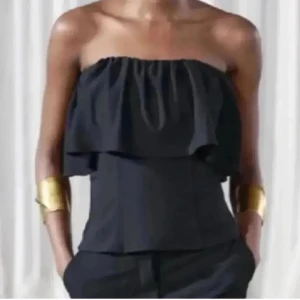 Trendig tubtopp med volang - Säljer en svart bandeau tubtopp med bred volang upptill. Trendig topp från Zara. Använd en gång💗