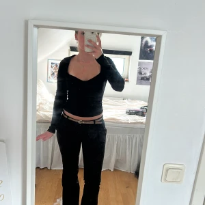 Svart ribbad topp - Säljer en stilren svart ribbad topp med långärmade ärmar. Toppen har en tight passform och en elegant design som passar perfekt till jeans eller kjol. Perfekt för både vardag och speciella tillfällen. Pris kan diskuteras