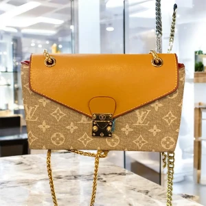 Low  axelväska med kedja - Snygg axelväska  i beige och vitt. Väskan har ett lock i ljusbrunt skinn, guldfärgad kedjerem och metallspänne framtill. Perfekt storlek för det viktigaste och ger en lyxig touch till din outfit.