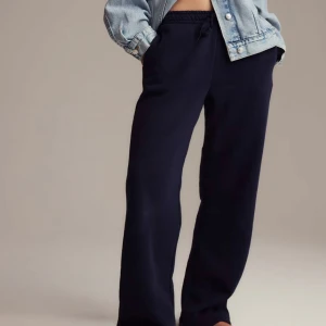 Marinblåa  mjukisbyxor med snörning - Snygga marinblåa mjukisbyxor med rak passform och elastisk midja med snörning. Perfekta för en chill och avslappnad stil. Byxorna är tillverkade i mjukt material som känns skönt mot huden. Lite noppriga vid låren annars bra skick 