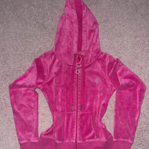 Rosa Lavish Luxury - Starkråsa zip up med glittrande logga på bröstet. Tröjan har huva, snörning och dragkedja framtill samt ribbade muddar och fickor. Perfekt för en chill och y2k look.