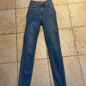  blå skinny jeans - Klassiska blå jeans med skinny passform och hög midja. Liten tråd som lossnat på fickan (bild 2). Längd 31