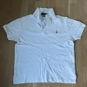 Vit pikétröja Polo Ralph Lauren - Vit pikétröja från Polo Ralph Lauren i slim fit-modell. Klassisk krage med knappar och broderad logga på bröstet. Tillverkad i mjuk bomull, perfekt för en golfrunda. Jätte skönt material , hör av dig vid fundering eller pris diskussion . Passar 170cm-180cm.55kg-74kg