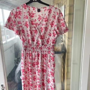 Vit långklänning med rosa blommor SHEIN - Långklänning från SHEIN i vitt med rosa blommigt mönster. 