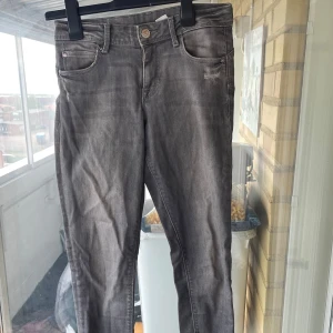 Grå jeans med smal passform - Snygga grå jeans med lätt tvättad look och klassisk femficksdesign. 