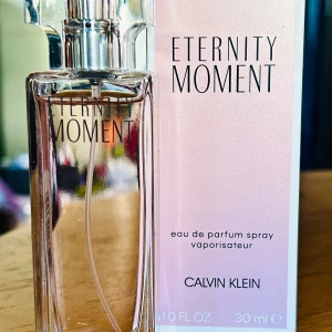 Calvin Klein Eternity Moment EDP! - Calvin Klein Eternity Moment EDP. 30 ml. Endast testad.                          Eternity Moment är en uppdaterad version av den klassiska doften Eternity från Calvin Klein. Eternity Moment, skapad för moderna, unga kvinnor, är en fräsch och blommig doft. Den är skapad för att fånga det där ögonblicket när två själar möts, de första blickarna och den första gången de rör vid varandra. Noterna i doften är litchi, pomegranat-blommor, vattenlilja, kinesisk rosa pion, guava, mysk och träiga noter.