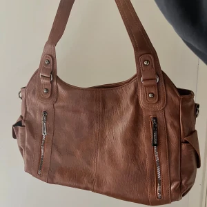 Orange/brun axelväska i läderimitation  - Helt nytt skick och oanvänd! 💕 rymmer ganska mycket i väskan. 38cm bred, 23 cm höjd 🫶🏻