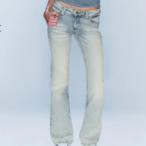 Ljusgrå bootcut jeans med vintagekänsla - Snygga ljusgrå jeans med bootcut-modell och låg midja. Jeansen har klassisk femficksdesign, slitna detaljer och en cool tvätt som ger en vintagevibe. Perfekta för dig som gillar en avslappnad men trendig look. Som nya 