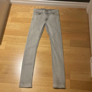 Grå skinny jeans från Cheap Monday - Säljer ett par ljusgrå skinny jeans från Cheap Monday i storlek 29/34. Jeansen har klassisk femficksdesign, smal passform och är tillverkade i mjukt bomullsmaterial med lite stretch. Perfekta för dig som gillar en clean och stilren look.