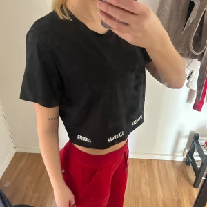 Svart croppad t-shirt med tryck - Svart tränings top ifrån STRONGER. Passar både S och M beroende på hur man vill ha passformen. 