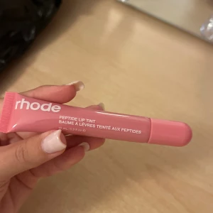 Rhode Peptide Lip Tint duo - (Alla nyanser finns,oöppnad. Med skal 299kr+) Säljer Rhode Peptide Lip Tint, en i ljusrosa och en i mörkröd nyans. Båda kommer i praktiska tuber på 10 ml och ger läpparna en snygg tint samtidigt som de återfuktar. Perfekt för dig som vill ha både en mjuk rosa och en djupare röd färg i sminkväskan.