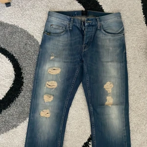 Tiger of Sweden Rocky ripped jeans - Blå jeans från Tiger of Sweden, modell Rocky, med slitna och trasiga detaljer framtill. Jeansen har klassisk femficksdesign, normal passform och är tillverkade i denim. Snyggt tvättade med ljusare partier och råa hål för en trendig look. Priset kan självklart sänkas vid snabb affär! Skriv vid funderingar. 