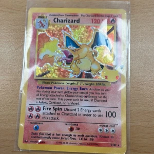 Charizard - Legendarisk Charizard Pokémonkort med holografisk effekt! Perfekt för samlare och fans som vill ha en ikonisk och cool kort i sin samling. Kortet är skyddat i plastficka och har Pikachu-stämpel. Ett måste för alla Pokémon-entusiaster!