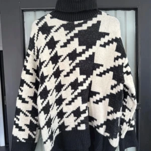 Svartvit polotröja🌸 - Säljer en oversized polotröja i svart och vitt med ett stort rutigt mönster. Tröjan är stickad och har en hög, ribbad polokrage. Superfint skick, ifrån H&M, storlek S. 