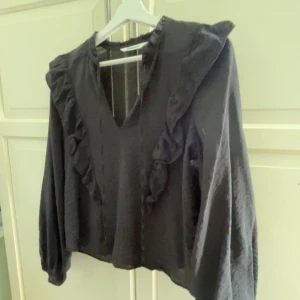 Svart blus med volang från Kappahl - Svart blus från Kappahl i storlek XS. Köpt för något år sedan men knappt använd på denna tiden !❤️