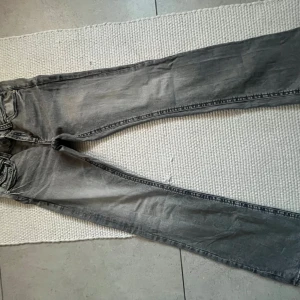 Grå jeans med smal passform - Snygga grå jeans med smal passform och klassisk femficksdesign. Jeansen har en något tvättad look och raka ben, perfekta till sneakers eller boots. Materialet är mjukt och följsamt jeans, vilket gör dem bekväma hela dagen.