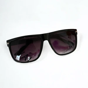 Rayban Boyfriend Liknande Solglasögon - Stilrena Rayban Boyfriend liknande solglasögon med svart, glansig båge i klassisk fyrkantig form. Glasen har en snygg lila toning som ger en cool vibe. Perfekta för att lyfta din look under soliga dagar.