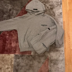 Essentials tracksuit - Väldigt stilig essentials fear of god tracksuit i grå Nästan helt nytt skick använd ett par fåtal gånger. Varm och skön passar perfekt nu till höst