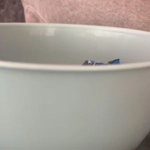 Godis skål med godis  - Bilderna visar en skål med godis, bland annat Bounty, samt ett svart föremål som kan vara ett fodral till trådlösa hörlurar. Ingen tydlig elektronikprodukt kan identifieras utifrån bilderna.