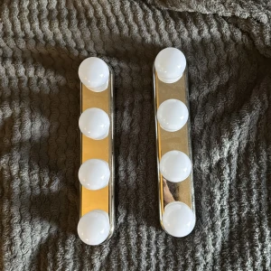 LED Sminkspegelbelysning 2-pack - Två stycken LED-lampor för sminkspegel med fyra lampor vardera. Monteras enkelt med sugproppar eller skruvas upp. Ger jämnt och starkt ljus, perfekt för sminkning eller styling. Fint skick, inga synliga defekter eller slitage. Batteri
