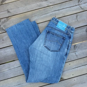 Ljusblå jeans från Jacob Cohen - Snygga ljusblå jeans från Jacob Cohen med hål  på ena knäet | Storlek 32 | Mått: 100cm längd, 42 cm midja | Mycket bra skick | Pris kan diskuteras 