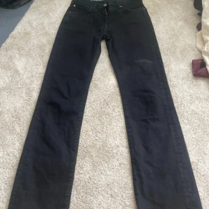Svarta low waist straight jeans - Svarta jeans med låg midja och raka ben. Klassisk femficksmodell med dragkedja och knapp framtill. Snygg och enkel stil som passar till det mesta. Materialet är jeans och färgen är djup svart.