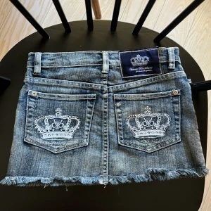 Victoria Beckham Rock & Republic Jeanskjol - Jättesnygg  jeanskjol i blå denim från Victoria Beckham for Rock & Republic. Står ingen storlek men skulle säga Xs eller s (mer åt den mindre sidan). Kjolen har fransad nederkant och broderade fickor. Tyvär är dragkedjan lite trasig, men det găr säkert att fixa. Det finns också knapp som kan användas istället för kedjan, så det finns inga problem men själva användningen. Fråga gärna för fler bilder och mått! 