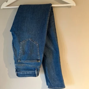 Blå jeans från Tiger of Sweden - Snygga blå jeans från Tiger of Sweden med klassisk femficksdesign och raka ben. Jeansen har normal midja och är tillverkade i mjukt denimtyg av bomull. Perfekta för dig som gillar stilrena och tidlösa jeans med en modern touch.