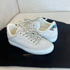 Zadig & Voltaire ”La Flash beaded” sneakers - Säljer supersnygga off white sneakers från Zadig & Voltaire ”La flash beaded”! Materialet är av mocka på utsidan och äkta läder på insidan! ❣️.    Skorna är endast använda 3 gånger och de skickas även med originalpåsen från Zadig  & Voltaire. ⚡️                                                            Säljer för 2600, nypris ca 3300-3400kr 
