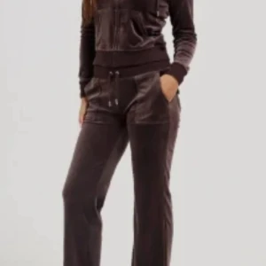 Juice sett - Mysiga bruna mjukisbyxor i sammetsmaterial med normal passform och snörning i midjan. Byxorna har raka ben och en skön, avslappnad stil som passar perfekt för chill dagar. Fickor framtill för extra funktionalitet. Knappt använda köpta för 1299 men pris kan diskuteras 