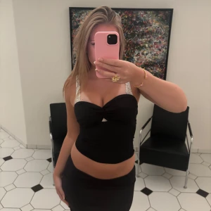 Svart tubtopp med twist framtill - Säljer en svart tubtopp med snygg twistdetalj framtill. Toppen är axelbandslös och har en tight passform som framhäver figuren. Ganska kort men ger fin form 💗