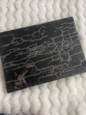 Contour Kit Tan to Deep Anastasia - Säljer en Contour Kit Tan to Deep från Anastasia Beverly Hills. Paletten innehåller sex olika nyanser i varma och neutrala toner för contouring och highlighting. Kommer i en svart kartongförpackning med guldtext. Perfekt för att skapa definierade ansiktsdrag.