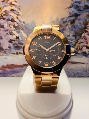 Guldig klocka från OXXO med svart urtavla - Snygg klocka från OXXO i guldigt metallarmband och svart urtavla. Klockan har stora siffror i guld, tre mindre urtavlor och en markerad bezel. Perfekt accessoar för dig som vill sticka ut med stilren och modern design.Rustad med nytt batteri, säljes i befintligt skick enligt bilderna!