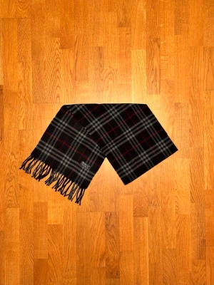 Mörkblå Burberry halsduk - Säljer en mörkblå halsduk från Burberry. Halsduken är i fint skick och är gjord i 100% lamull. Var inte rädd för några frågor. Pris diskuteras inte!