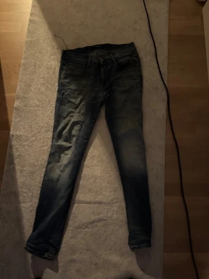 Blå Replay jeans med dragkedja - Snygga blå jeans från Replay med klassisk femficksdesign och dragkedja i gylfen. Jeansen har en något tvättad look och raka ben. Perfekta för dig som gillar en avslappnad men stilren stil.