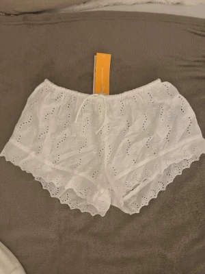 Vita lågmidjade shorts - Lågmidjade vita shorts i broderie anglaise. De är i barnstorlek 146/152 men passar mig som brukar ha xs/32 i shorts!  Helt nya med lappen kvar 🥂 Pris kan alltid diskuteras 💗